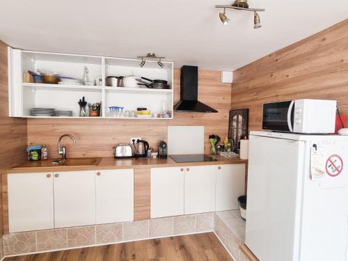 une cuisine avec des armoires blanches et un réfrigérateur blanc dans l'établissement Grand Studio Lumineux pour 4 personnes, à Bois-dʼArcy