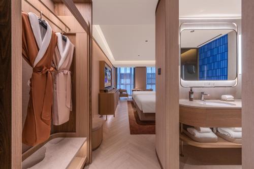 上海Crystal Orange Hotel Shanghai International Tourism Resort Pudong Airport的房间里有带水槽的浴室和一张床