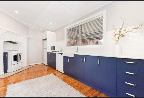 a kitchen with blue cabinets and a vase of flowers at San Mateo Cottage in Mildura