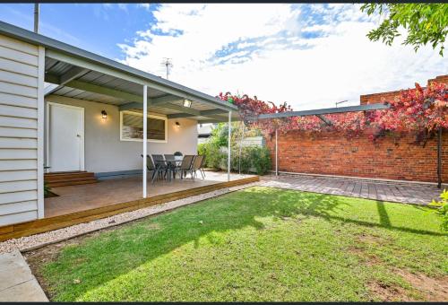 a home with a patio and a brick wall at San Mateo Cottage in Mildura