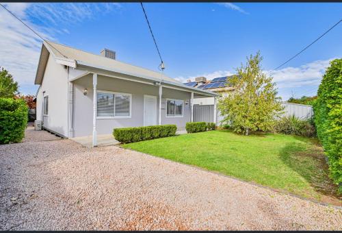 a white house with a gravel driveway at San Mateo Cottage in Mildura