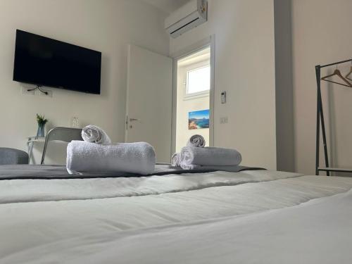 a bedroom with a white bed with towels on it at Blu Eracleo in Trapani