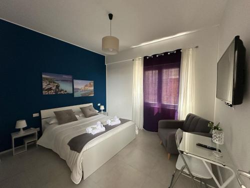 a bedroom with a bed and a tv and a chair at Blu Eracleo in Trapani