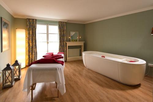 a large white bath tub in a room at Hotel am Schlosspark in Gotha