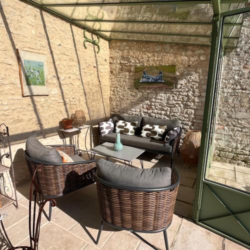 d'une terrasse avec un canapé, des chaises et une table. dans l'établissement Le Clos des Vignes, à Notre-Dame-de-lʼIsle