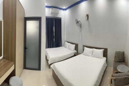 a small room with two beds and a mirror at Hoàng Gia 2 Hotel in Ấp An Phú