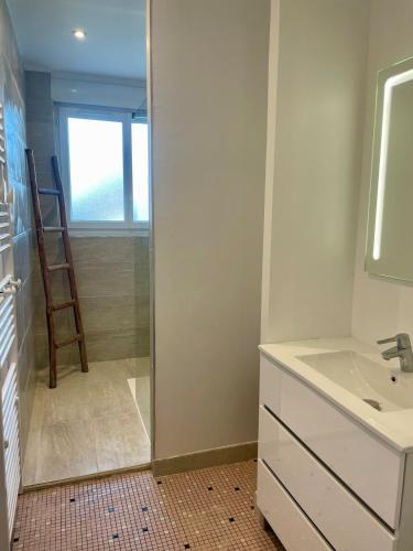 une salle de bain avec un lavabo et un miroir dans l'établissement Villa des Braves in Omaha Beach, sea view, à Saint-Laurent-sur-Mer