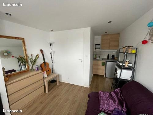 un salon avec un canapé et une cuisine dans l'établissement Studio fonctionnel, à La Celle-sous-Gouzon