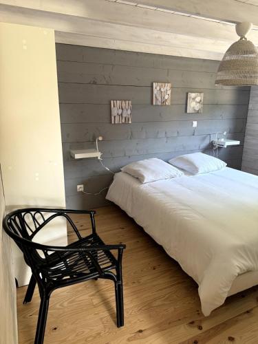 une chambre avec un grand lit et une chaise dans l'établissement Superbe logement 5 places Chalet 5, à Banassac