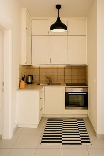 a kitchen with white cabinets and a sink at Maria Plomari Apartments in Plomarion