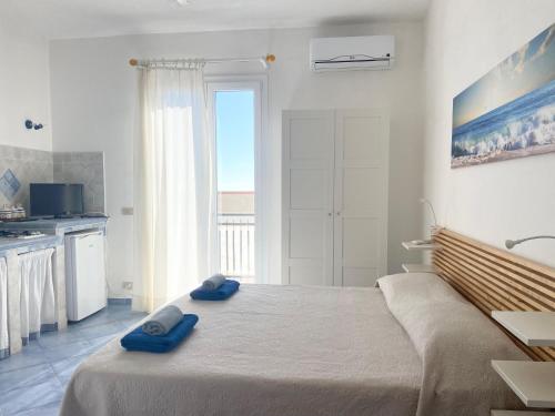 a bedroom with a bed with two blue towels on it at Rosa Dei Venti Marettimo in Marettimo