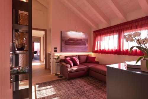 a living room with a couch and red curtains at Ca' Apollonio Heritage in Romano D'Ezzelino