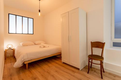 une chambre avec un lit, une chaise et une fenêtre dans l'établissement Le Pavois, à Marseille