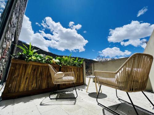 a patio with two chairs and a fence with flowers at Siguniangshan Town Tingshan Wild Luxury B&B in Mount Siguniang