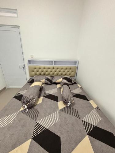a bedroom with a bed with a checkered floor at De Haus Villa Syariah Sukabumi in Krawang