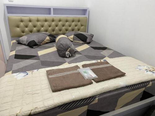 a bedroom with a bed with a checkered bedspread at De Haus Villa Syariah Sukabumi in Krawang