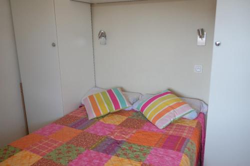 une chambre avec un lit avec deux oreillers dessus dans l'établissement Cabane de pêcheurs, à Pérols