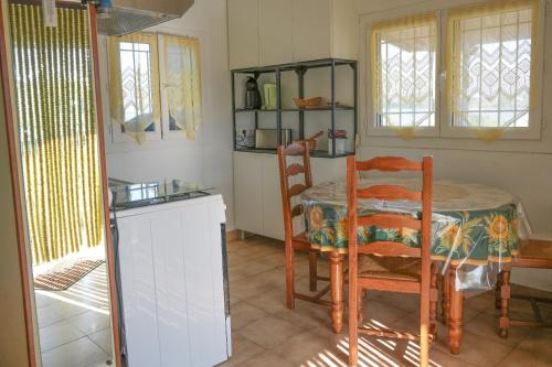 une cuisine avec une table et des chaises dans une pièce dans l'établissement Cabane de pêcheurs, à Pérols