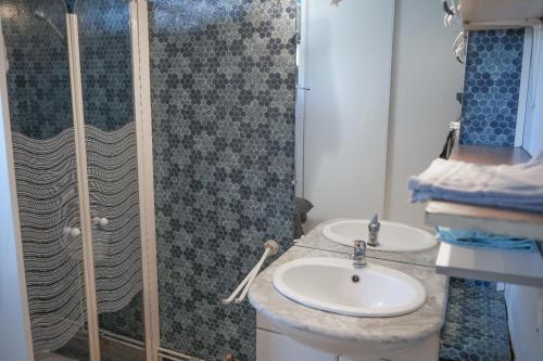 une salle de bain avec deux lavabos et une douche dans l'établissement Cabane de pêcheurs, à Pérols