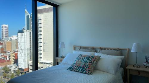 a bedroom with a bed with a large window at Perth Hub in Perth