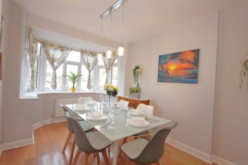 a dining room with a white table and chairs at Stunning 3 Bedroom 2 Bathroom Bungalow by CozyNest in Earley