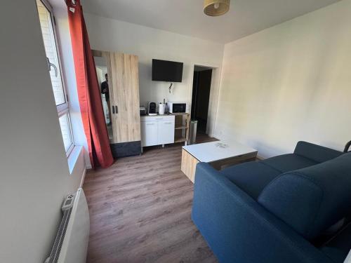 un salon avec un canapé bleu et une table dans l'établissement studio neuf Palais des Congrès Porte Maillot 20, à Levallois-Perret