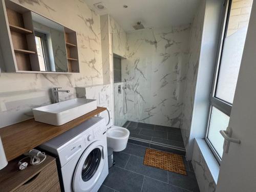 une salle de bain avec un lavabo et une machine à laver dans l'établissement studio neuf Palais des Congrès Porte Maillot 20, à Levallois-Perret