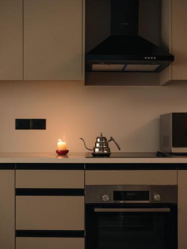 a kitchen with a tea kettle and a candle on the counter at Brassbell Zamalek Diplomatic Zone Near Marriott in Cairo