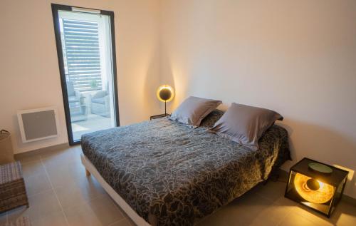 une chambre avec un lit et une grande fenêtre dans l'établissement Charmant T2 proche centre ville et terrasse, à Propriano