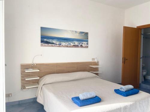a bedroom with a bed with two blue towels on it at Rosa Dei Venti Marettimo in Marettimo