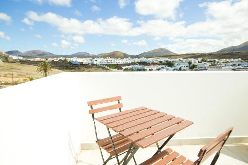 a wooden bench on a balcony with a view of a city at Casa Carann - By AZ Rentals in Uga
