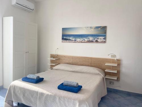 a bedroom with a bed with two blue pillows on it at Rosa Dei Venti Marettimo in Marettimo
