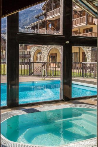 une vue d'une piscine à travers une fenêtre dans l'établissement travelski home premium - Résidence Les Alpages de Val Cenis, à Les Champs