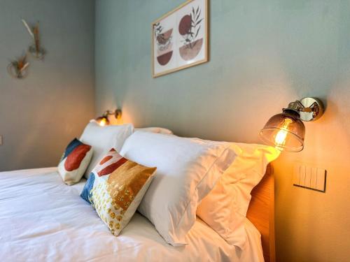 a bedroom with a bed with pillows and a lamp at Sogni di Paglia - Eco Country House in Monforte dʼAlba