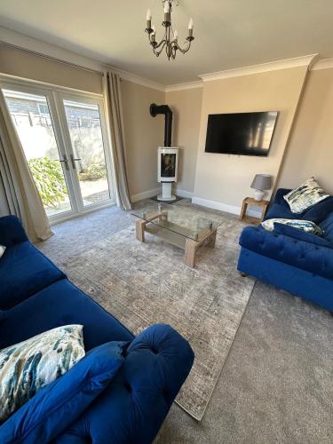 a living room with blue couches and a tv at Luxury, Tranquillity Near Beach in Carbis Bay
