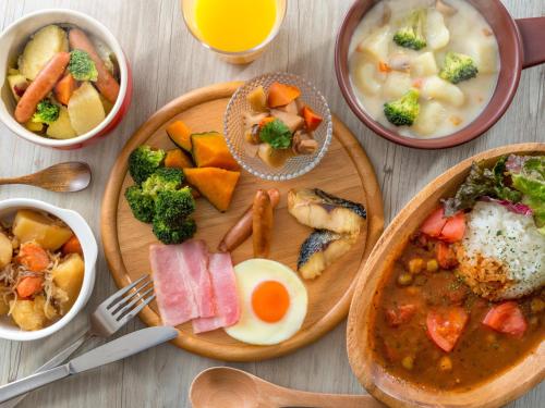 a table with plates of food and bowls of soup at HOTEL MYSTAYS Fuji Onsen Resort in Fujiyoshida