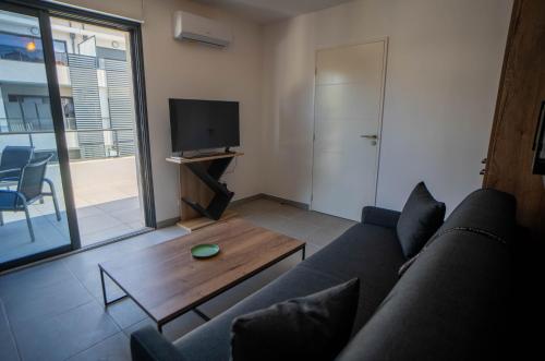 un salon avec un canapé et une table basse dans l'établissement Studio moderne et lumineux, proche centre ville, à Propriano