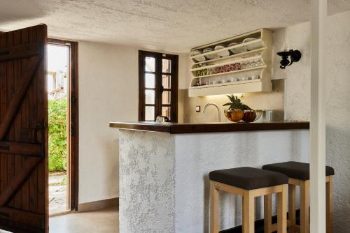 a kitchen with a counter and stools in a room at Mila Malia Studios Hotel in Malia