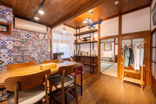 a dining room with a wooden table and chairs at Victory Guesthouse in Pingtung City