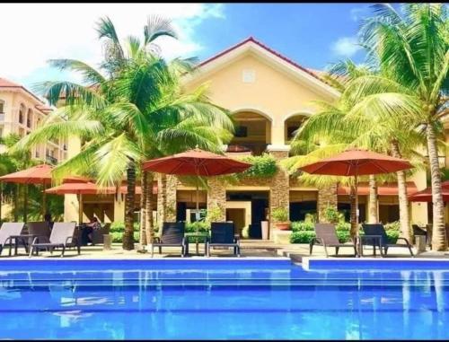 a resort with a swimming pool with chairs and umbrellas at San Remo Oasis in Cebu City