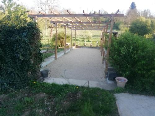 a garden with a wooden pergola and some bushes at Belle villa in Bourg-de-Péage