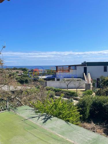 a house on a hill with a green yard at I Mirti in Stintino