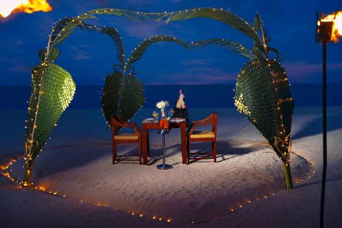 a table in the shape of a heart on the beach at The Calm Resort & Spa in Pasikuda