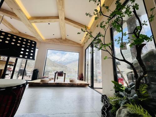 a room with a large window with a mountain view at Siguniangshan Town Tingshan Wild Luxury B&B in Mount Siguniang