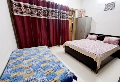 a bedroom with a bed and a red curtain at Hotel Lord #krishna Home Stay in Mathura