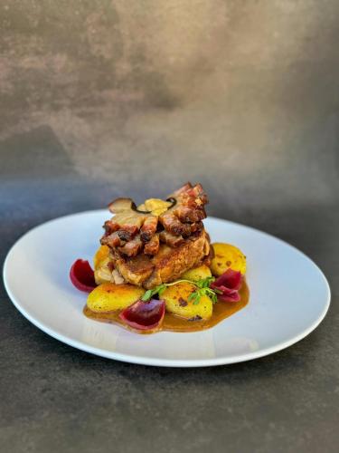 a white plate with food on a table at Belvárdi Fogadó in Belvárdgyula