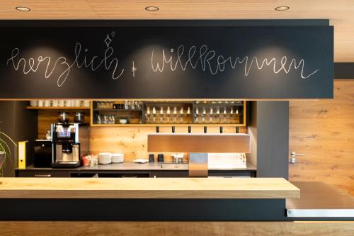 a restaurant with a black sign on the wall at Landgasthof Linde - In ruhiger, ländlicher Umgebung in Deggenhausertal