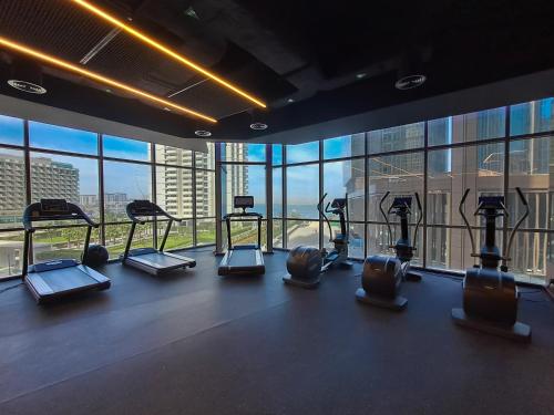 a gym with several treadmills in a room with windows at JBR Coastal Escape - Amazing Sea Views, Pool & State-of-the-Art Gym in Dubai