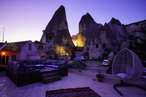 a patio with a chair and some rock formations at Glory Art Stone House in Goreme