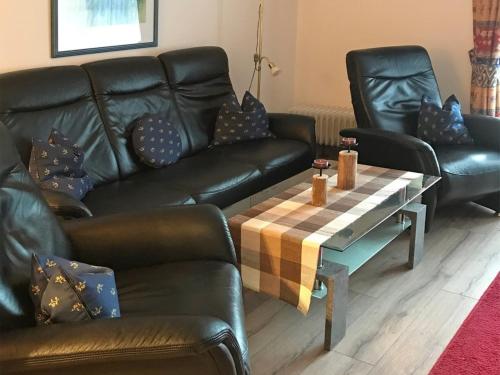 - un salon avec un canapé en cuir et une table basse dans l'établissement Ferienhaus Nr 28, Kategorie Königscard, Feriendorf Hochbergle, Allgäu, à Lechbruck am See